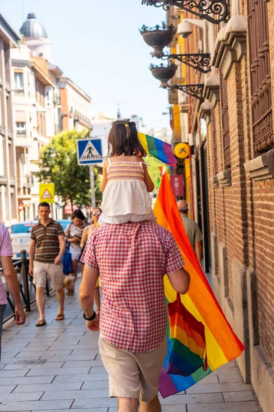 Families with children and with the lgbt flags in the streets at the pride party in Madrid