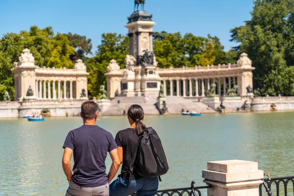 Tourists next to the lake of the Estanque Grande de El Retiro in the city of Madrid. Spain