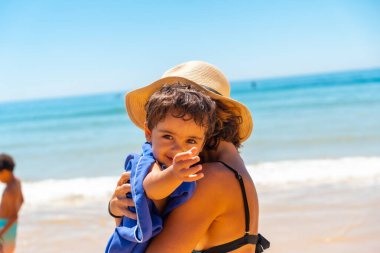 Mother hugging and having fun with her son by the sea, Algarve beach, Albufeira. Portugal