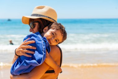 Mother hugging her son by the sea on vacation, Algarve beach, Albufeira. Portugal
