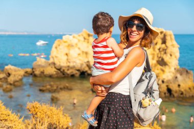 Mother with her son at Praia dos Arrifes, Algarve beach, Albufeira. Portugal. tourism in summer