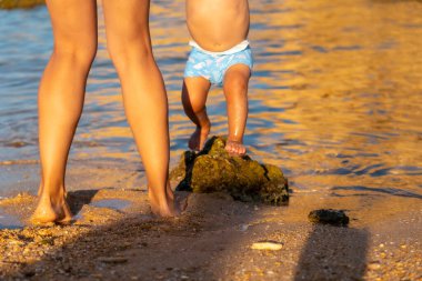 Playing with her baby in summer at Praia dos Arrifes, Algarve beach, Albufeira. Portugal