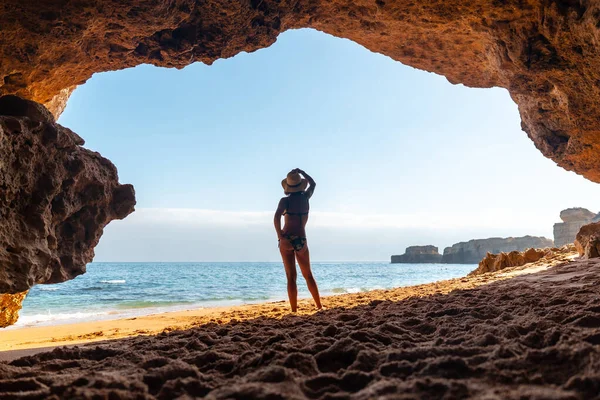 Silhouette of a woman in the cave on the beach in the Algarve, Praia da Coelha, Albufeira. Portugal