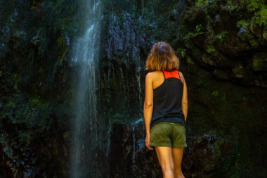 An unrecognizable young woman at the waterfall at the Levada do Caldeirao Verde, Queimadas, Madeira