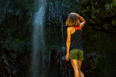 An unrecognizable young woman at the waterfall at the Levada do Caldeirao Verde, Queimadas, Madeira