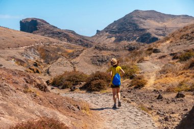 Young woman tourist on a trekking trail in Ponta de Sao Lourenco in summer, Madeira coast
