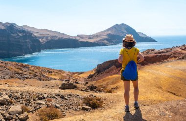 A young woman tourist on the Ponta de Sao Lourenco trail in Baia D'Abra by the beach, Madeira coast