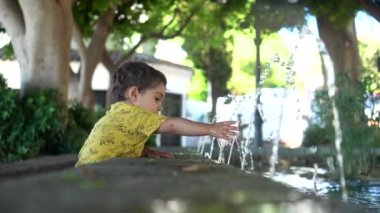 Malaga 'nın Mijas belediyesindeki çeşmede sıcaktan serinleyen bir bebek. Endülüs