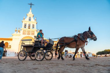 Gün batımında at sırtında turistler Rocio festivalinde El Rocio tapınağında, Huelva