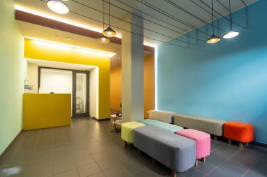 Renkli kanepeleri olan modern bir diş kliniğinin bekleme odası.