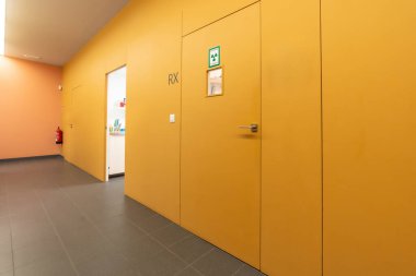 Bir diş kliniğinin koridorunda birden fazla kutu ve röntgen odası var.