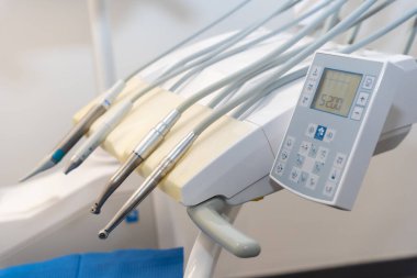 Ameliyat için sandalyenin yanındaki modern bir diş kliniğinde doktorlar tarafından kullanılan aletler.