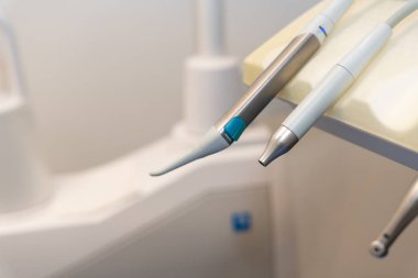 Ameliyat için sandalyenin yanındaki modern bir diş kliniğinde doktorlar tarafından kullanılan aletler.