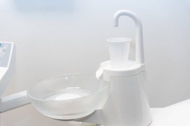Diş kliniğinde ağzını suyla çalkalamak için plastik bardak.