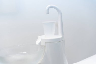 Diş kliniğinde ağzını suyla çalkalamak için plastik bardak.