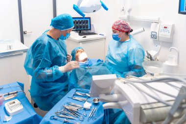 Diş hekimliği, dişçi doktoru ve asistanı ameliyattan önce tüm aletleri hazırlıyorlar.