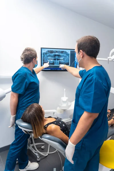 Hammashoitola Potilas Juttelemassa Hammaslääkäreille Röntgenkuvasta — kuvapankkivalokuva