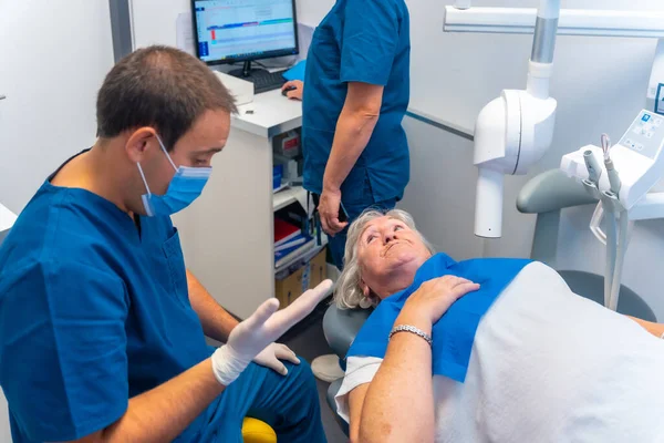 Klinika Stomatologiczna Lekarz Dentysta Asystent Tłumaczący Starszej Kobiecie Badania Stomatologiczne — Zdjęcie stockowe