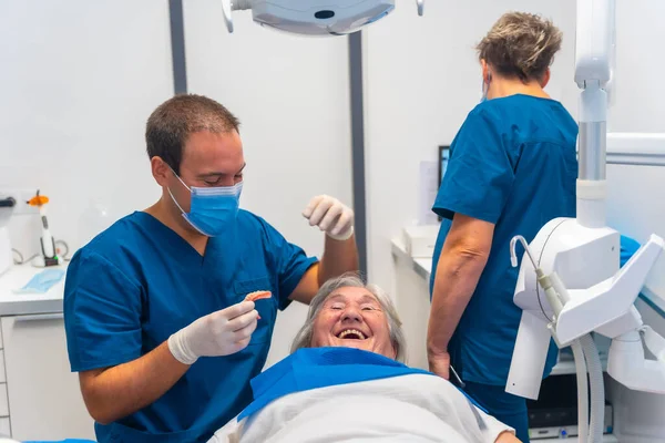 Klinika Stomatologiczna Lekarz Dentysta Dobrze Się Bawiący Starszą Kobietą Leżącą — Zdjęcie stockowe