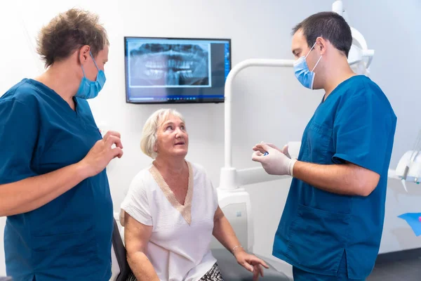Zahnklinik Zahnarzt Und Assistent Erklären Einer Älteren Frau Zahnbehandlung Prothese — Stockfoto