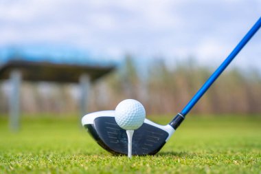 Gölün kenarında golf oynayan bir adam, vurmaya hazırlanıyor.