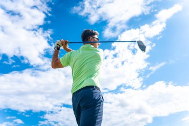 Profesyonel bir golf sahasında sopa sopasıyla topa vuran bir golfçünün ayrıntıları.