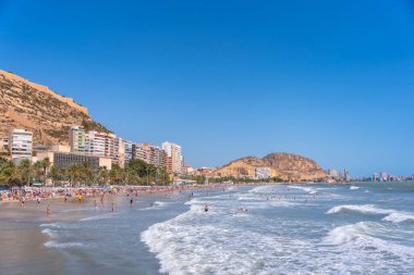 Alicante şehrindeki Postiguet plajında turistler ve Santa Barbara Kalesi