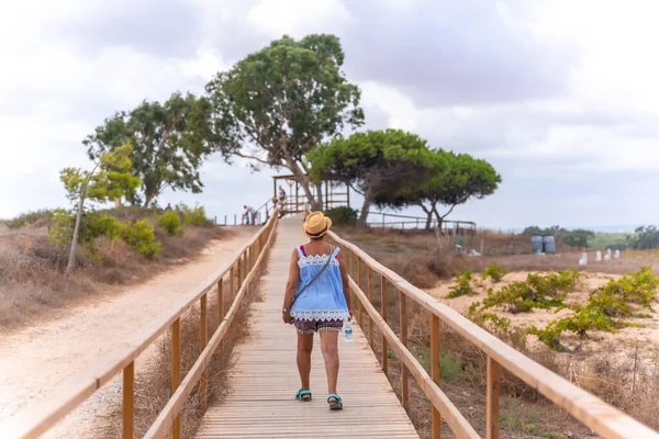 An older tourist walking next to the lagoon in La Mata Natural Park in Torrevieja, Alicante