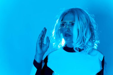 Gelecekten gelen gözlüklü, mavi arka planda genç bir kadının silüeti.