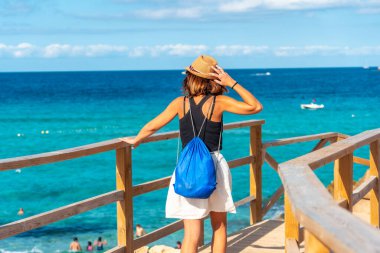 İlkbaharda İbiza adasındaki Cala Comte plajında bir turist. Gün batımı. Balearic