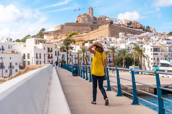 A young woman on spring vacation in Ibiza town next to the lighthouse, Balearic Islands