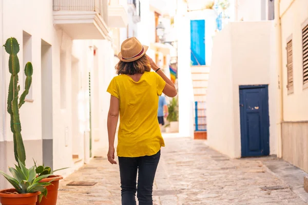A young woman with a hat visiting the old town of Ibiza, Balearic Islands, Eivissa