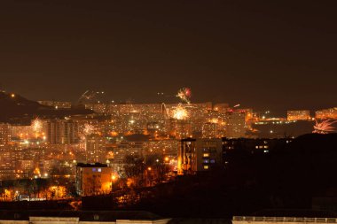 Yeni yıl kutlamaları sırasında gece şehirde havai fişekler. Yumuşak odak arkaplanı