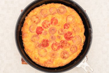 Sıcak hava fırınından çıkmış sosisli, domatesli ve peynirli ev yapımı pizza yemeye hazır. Seçici odaklı üst görünüm. Pizza pişirme süreci, 12. adım