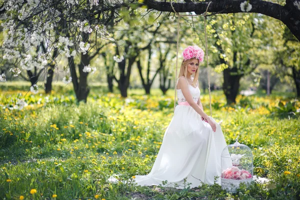 Mooi meisje is poseren met bloemen — Stockfoto