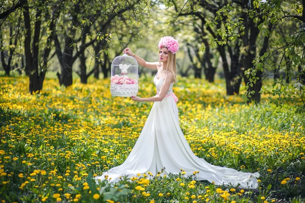 Joven chica bonita está posando con flores — Foto de Stock
