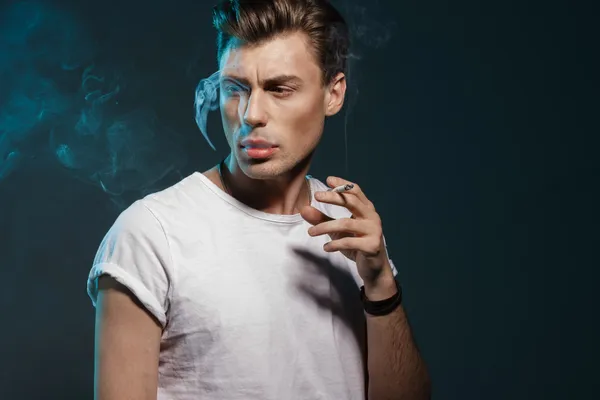 Beau jeune homme fumant de la cigarette — Photo