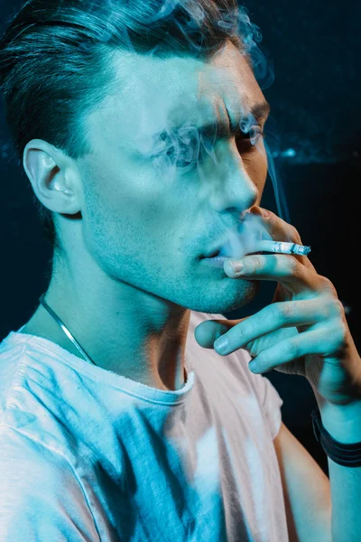 Handsome young man smoking cigarette — Stock Photo, Image
