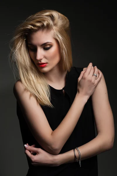 Beautiful blond woman with long hairstyle poses at studio — Stock Photo, Image