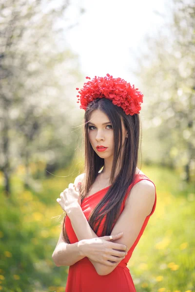 Mooi meisje poseren in zomer veld met bloemen — Stockfoto