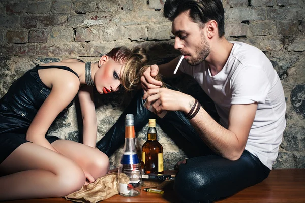 Le couple avec des cigarettes et de l'alcool — Photo
