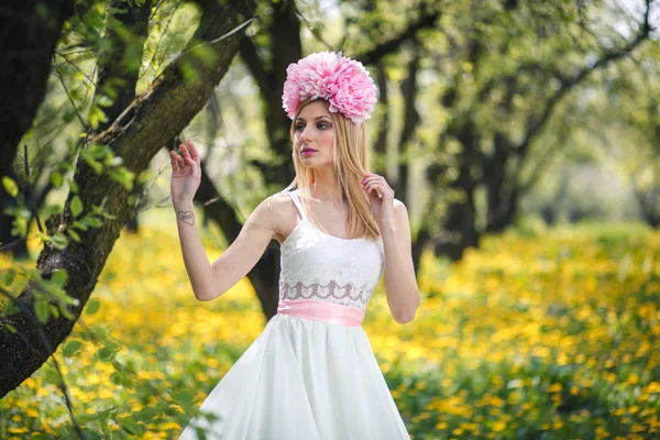Young pretty girl is posing with flowers — Stock Photo, Image