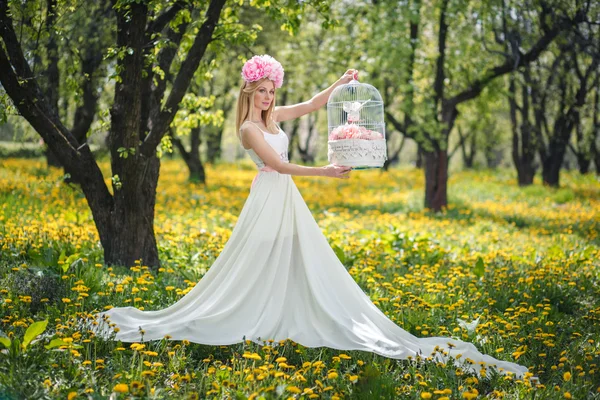 Joven chica bonita está posando con flores — Foto de Stock