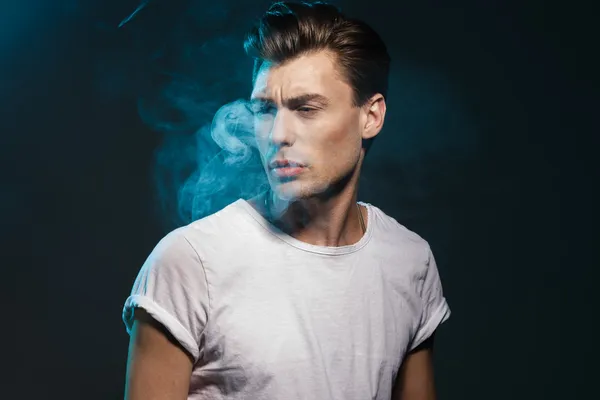 Handsome young man smoking cigarette — Stock Photo, Image