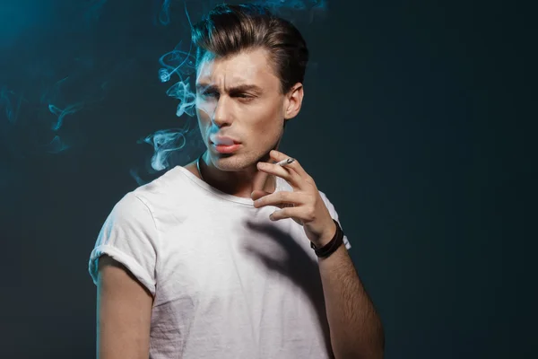 Beau jeune homme fumant de la cigarette — Photo