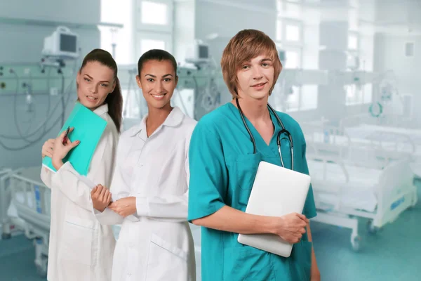 Artsen opstaan terwijl glimlachend in een operatiekamer Stockafbeelding
