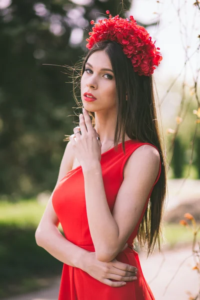 Joven chica bonita está posando con flores — Foto de Stock