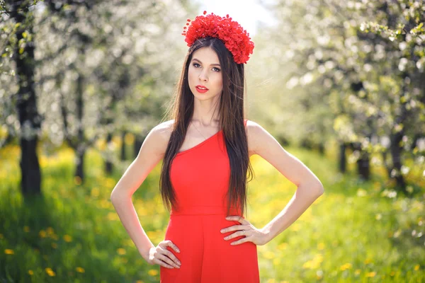 Young pretty girl posing in summer field with flowers — Stock Photo, Image
