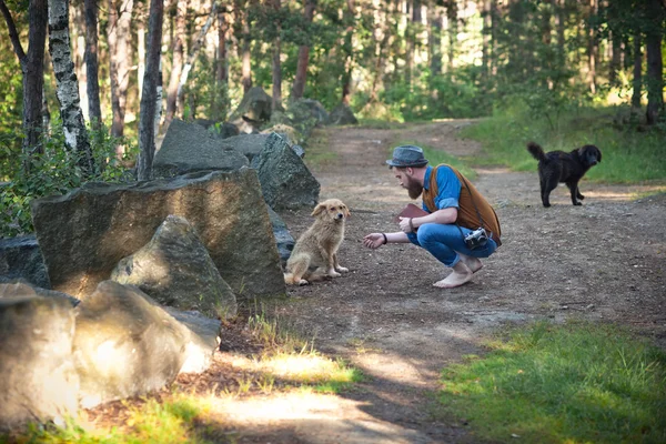 Mann streichelt Hund im Wald — Stockfoto