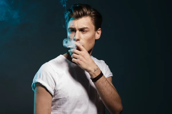 Handsome young man smoking cigarette — Stock Photo, Image